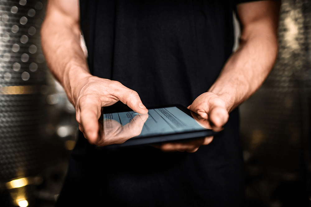 Close-up of a person in a black shirt using a tablet.