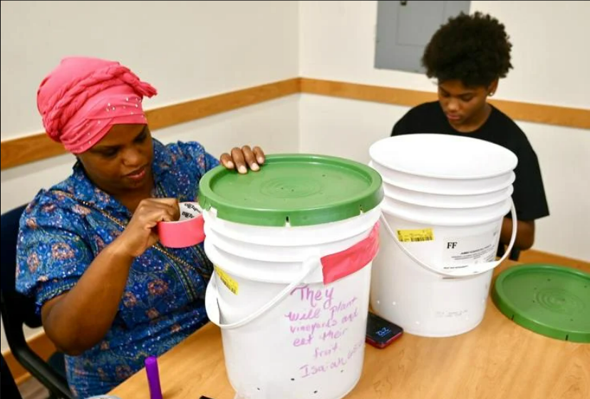 Ayanna Ferguson of Indian Head and her son Avian, decorate a compost bucket at the Charles County Library Potomac Branch Saturday afternoon during a workshop hosted by the Alice Ferguson Foundation