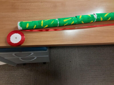 Lay the toilet paper tubes end to end and cut a ribbon a little longer than the tubes as the extra will serve as the snake’s tongue.